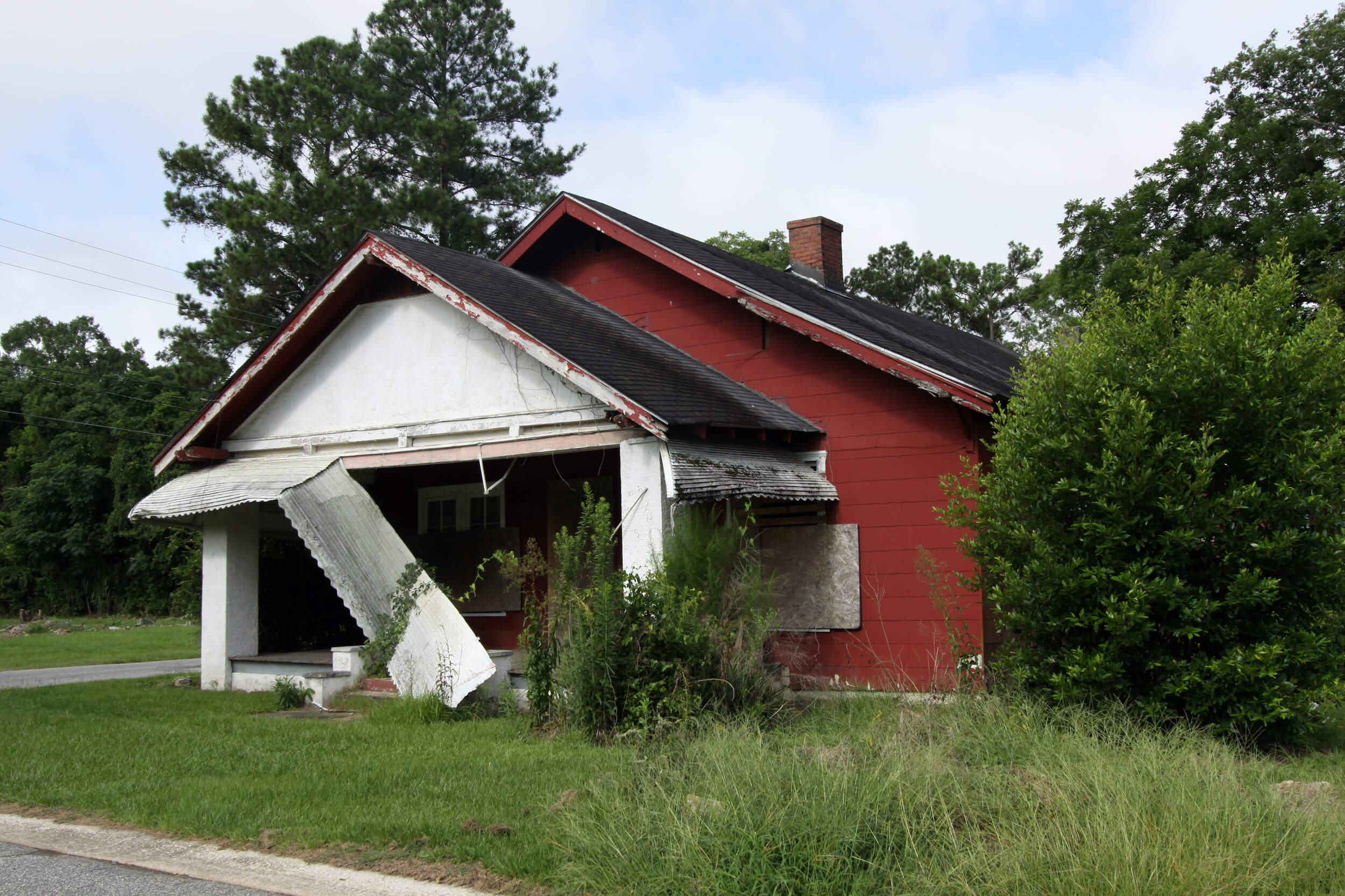 an abandoned building with a caved-in porch