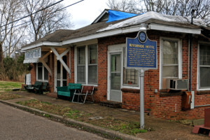 facade of an older motel with a historic plaque