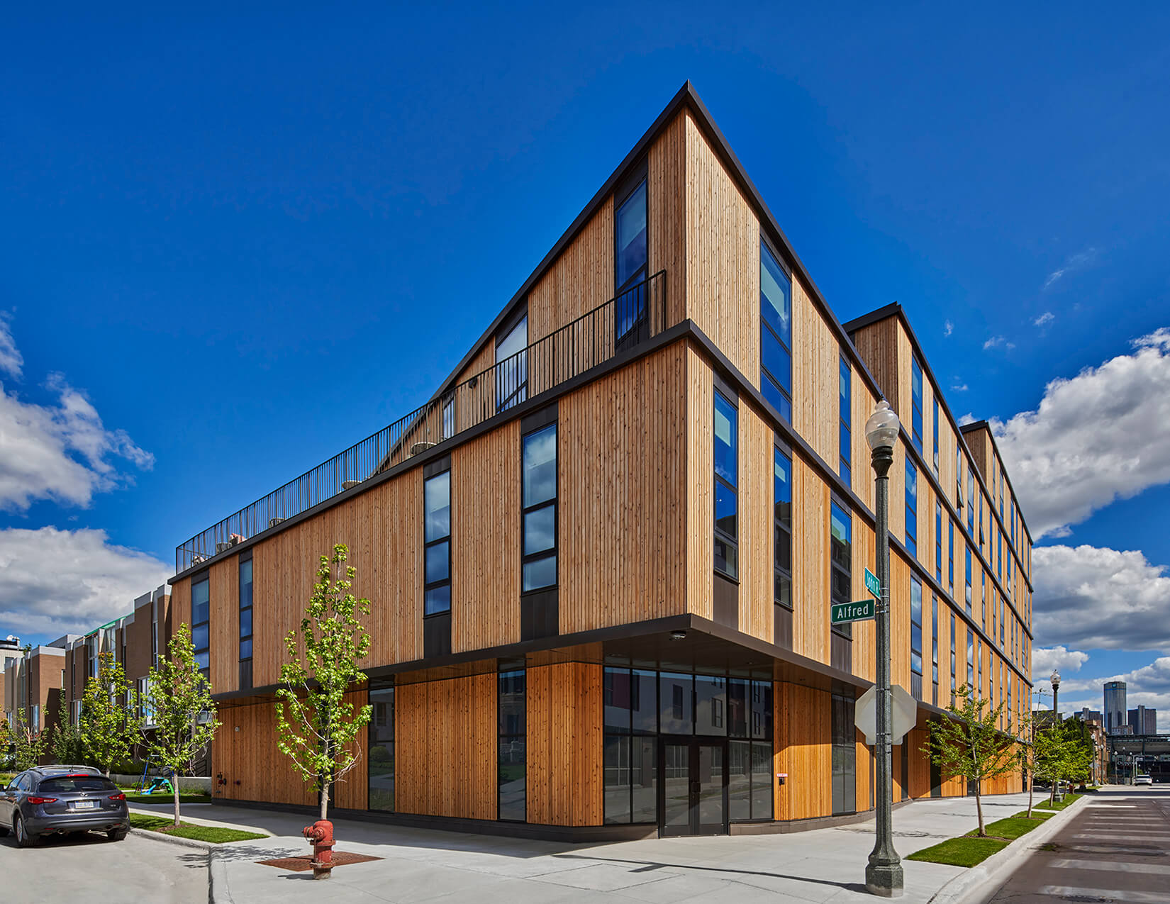 photograph depicting a contemporary apartment building clad in cedar vertical boards