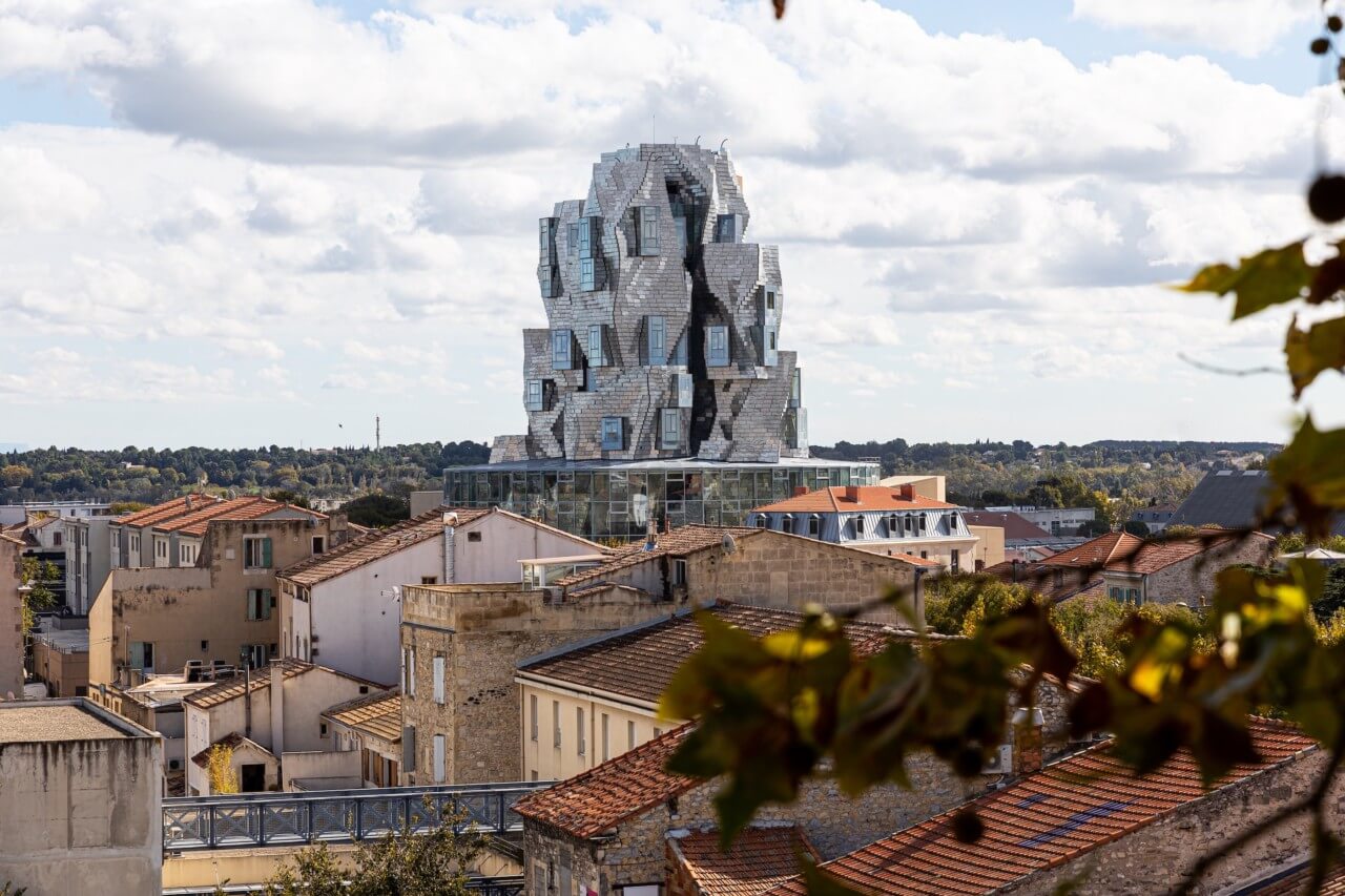 A modern sculptural tower rises above the historic buildings of Loma Arles