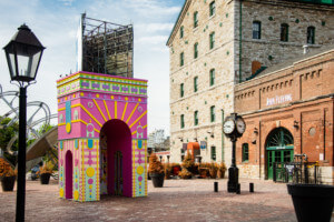 a pastel colored temporary pavilion in a historic square for toronto's winter stations