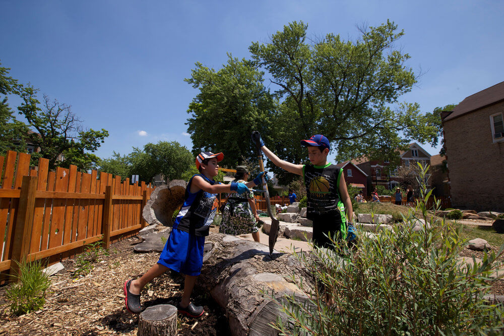 photo depicting two children assisting in the maintenance of a community Garden in Chicago