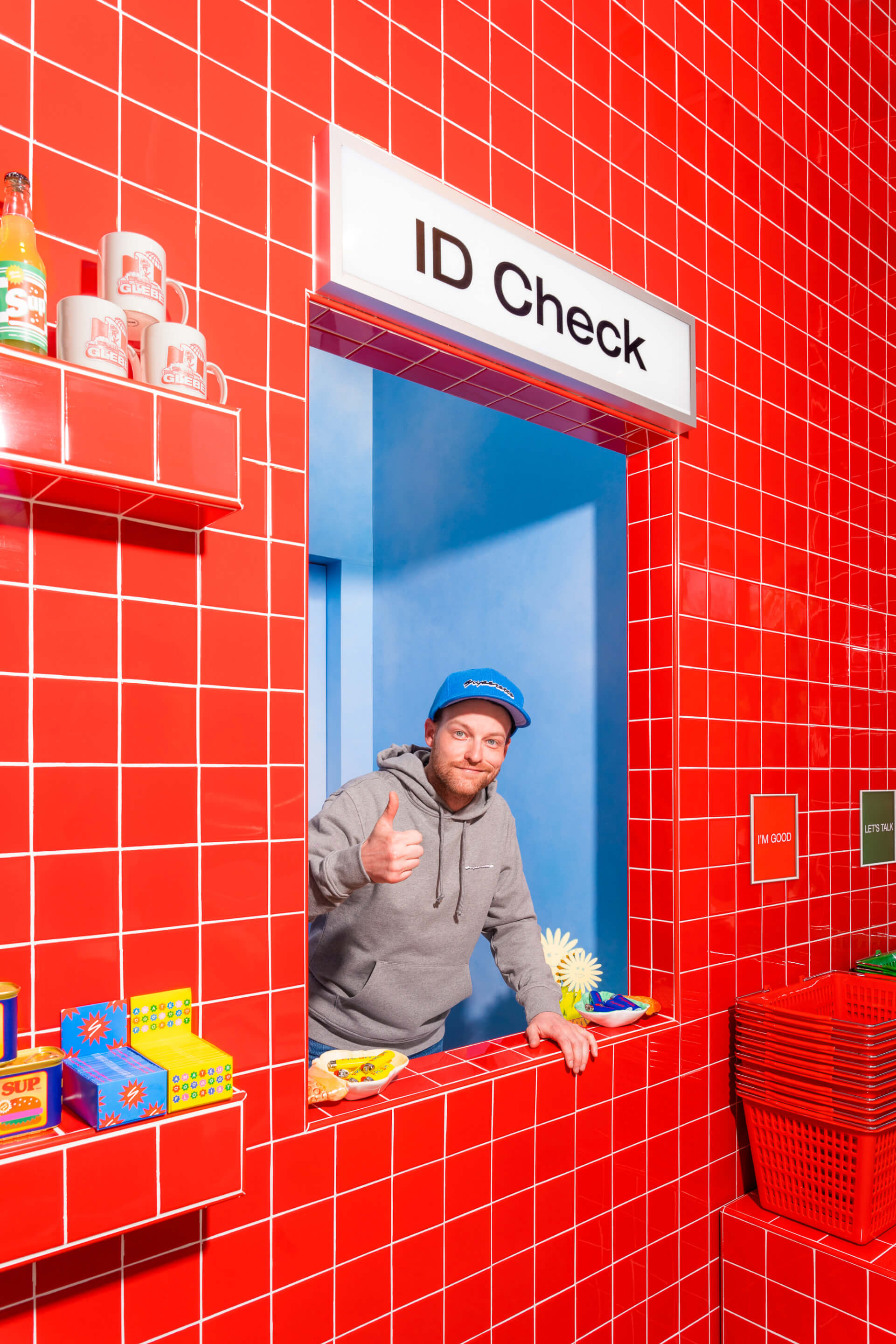 a man gives thumbs up from an id check window in a Superette