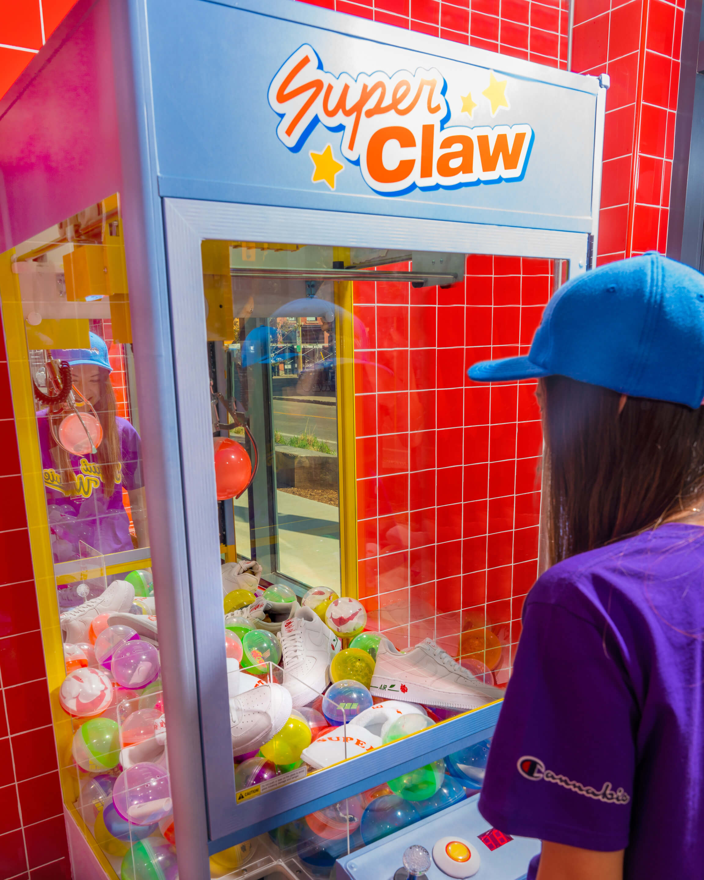 a person playing a claw machine game inside of a Superette