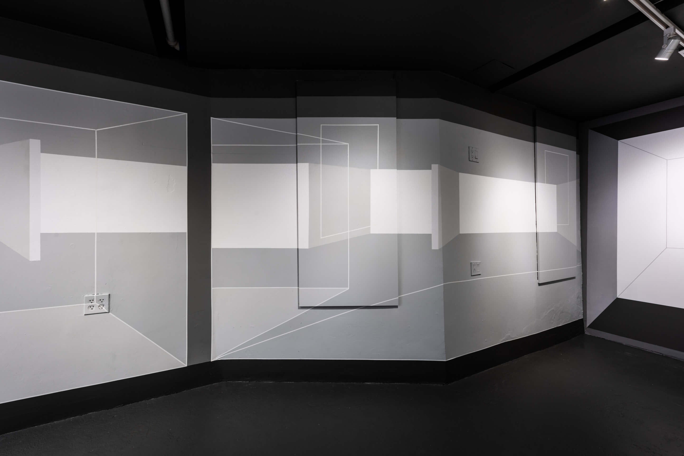 Interior of a grey gallery with lines covering the walls