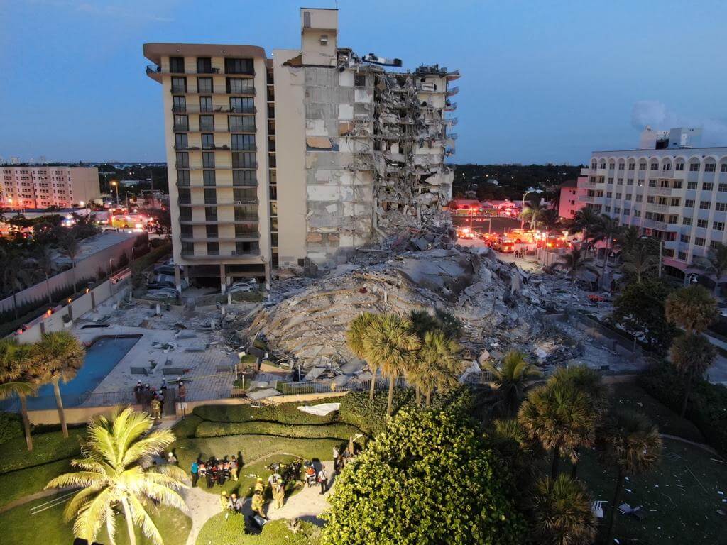 A miami tower collapse at dawn, with first responders on scene