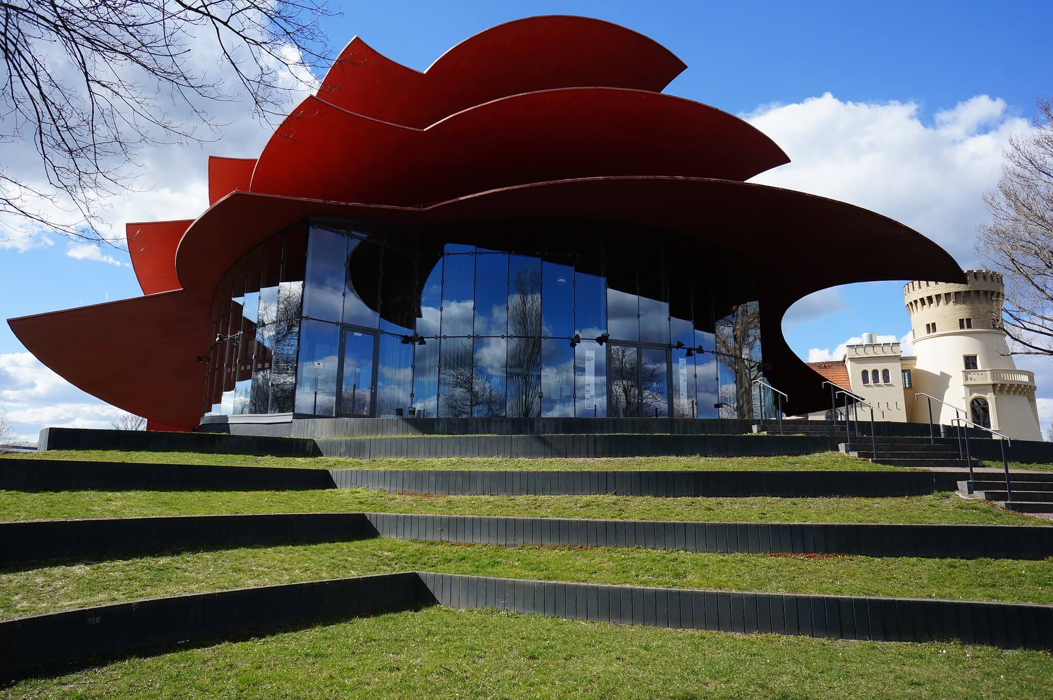 a modern theater building with a red-petaled roof