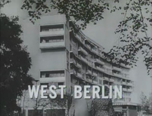 Black and white screencap of a berlin housing development on television