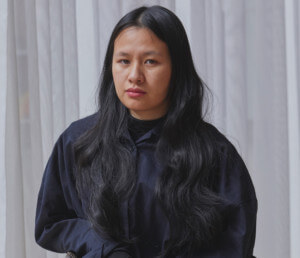 Trang Tran, a young asian american woman, posing in a chair
