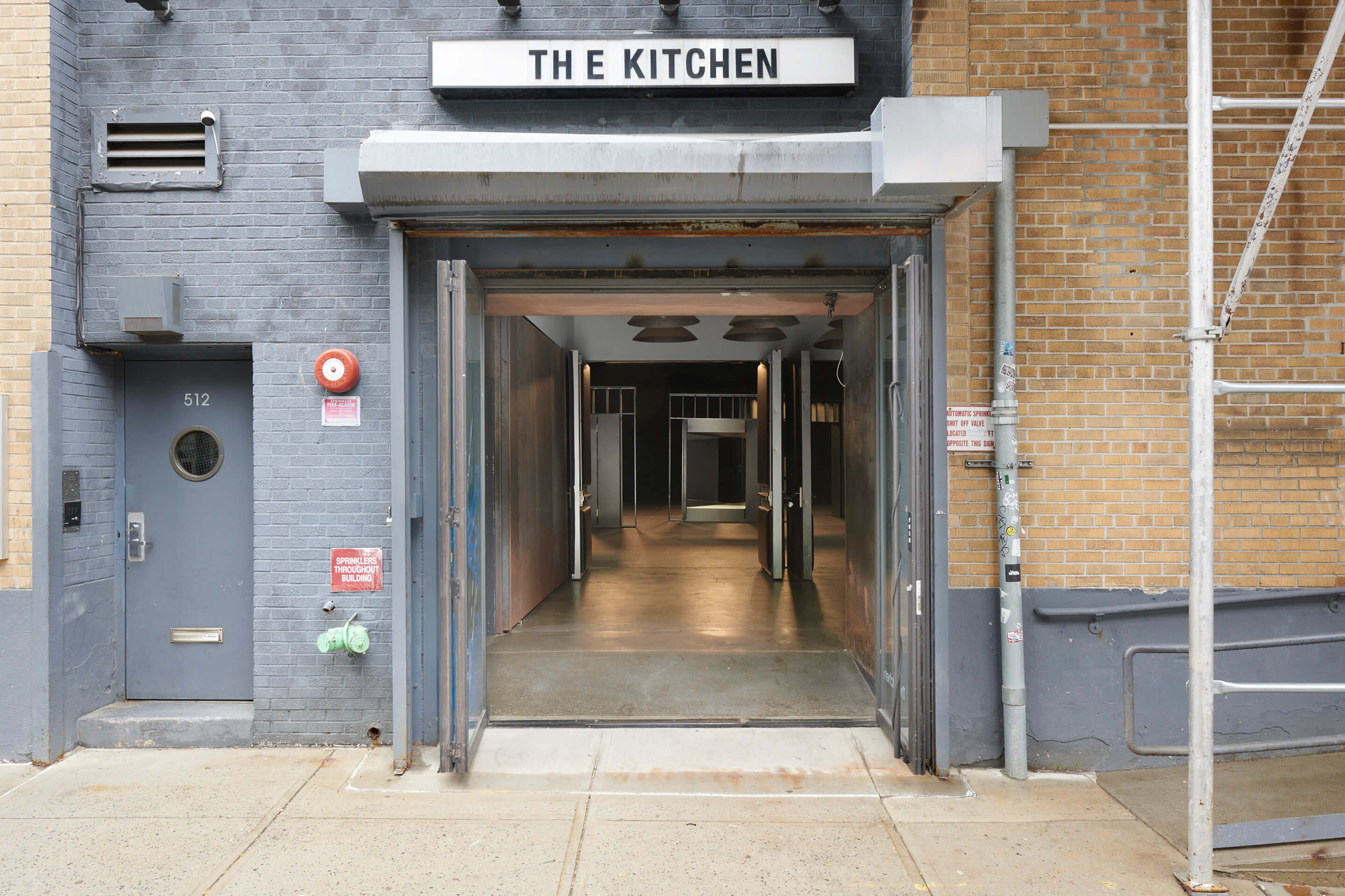 Looking into a storefront with a the kitchen sign, and the Container and Contained show within