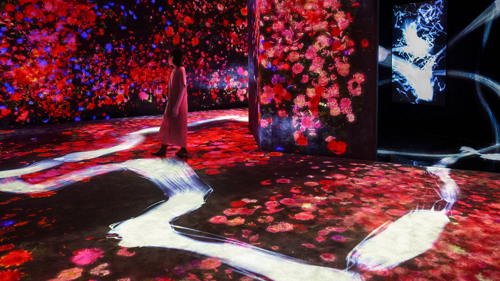 A woman walking among projected red petals
