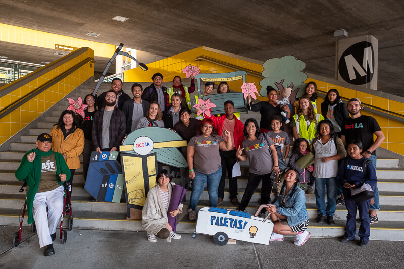 A group of activists posing in front of an LA metro station