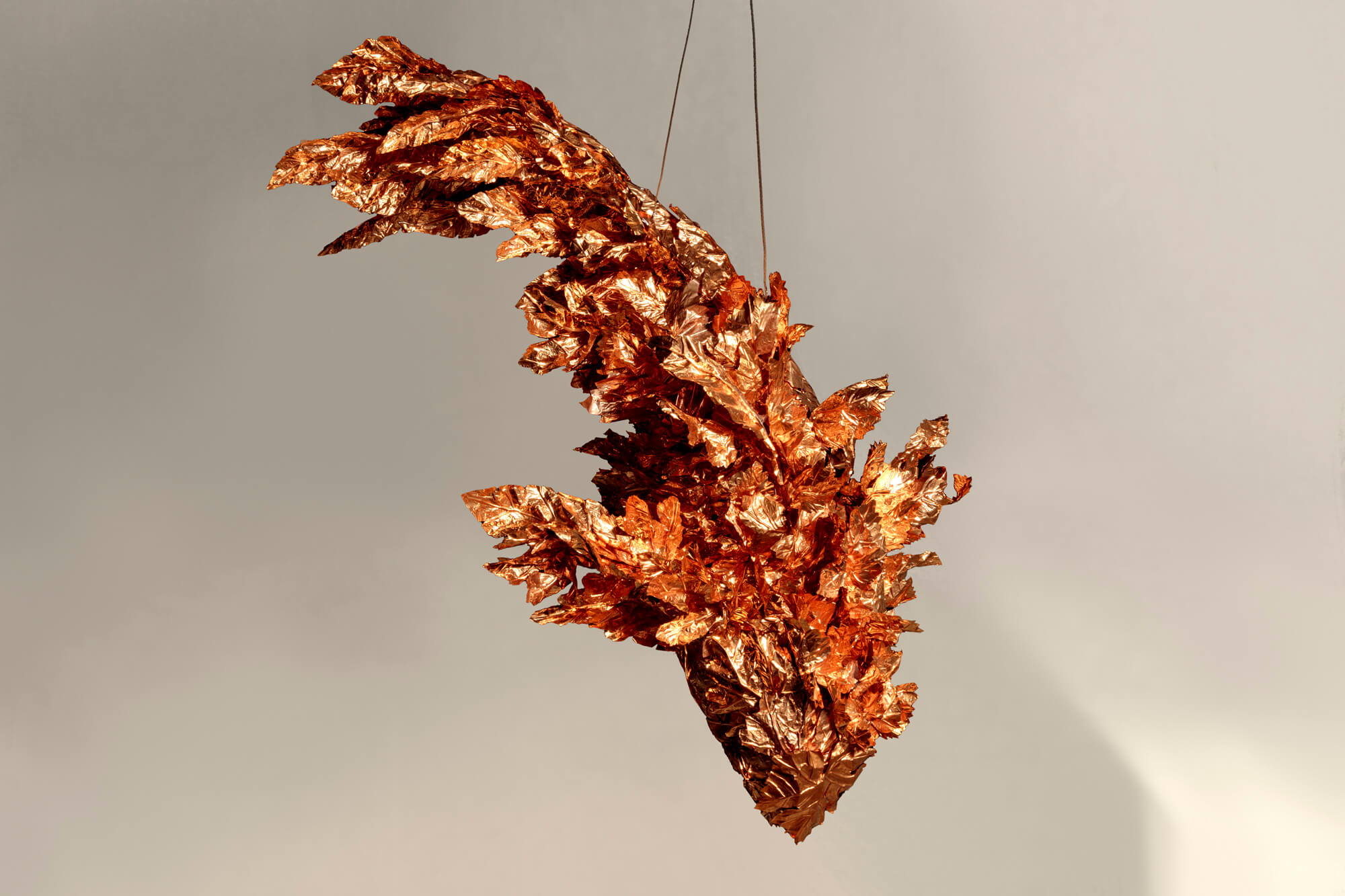 a bronze sculpture of a fish, hanging from the ceiling as part of spinning tales
