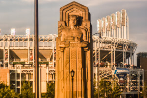 a statue of the cleveland guardians holding a carriage ahead of a baseball stadium