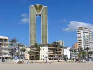 an m-shaped skyscraper rising over a beach, Intempo