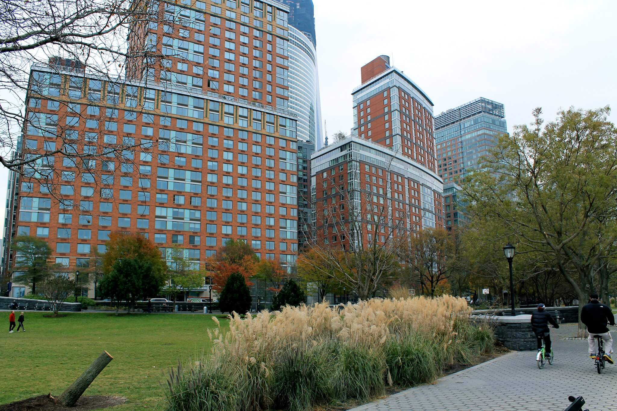 view of a city park in manhattan with tall towers looming over it