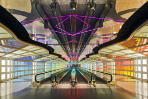 interior photograph of an airport concourse with purple neon tubing and colorful side walls designed by helmut jahn
