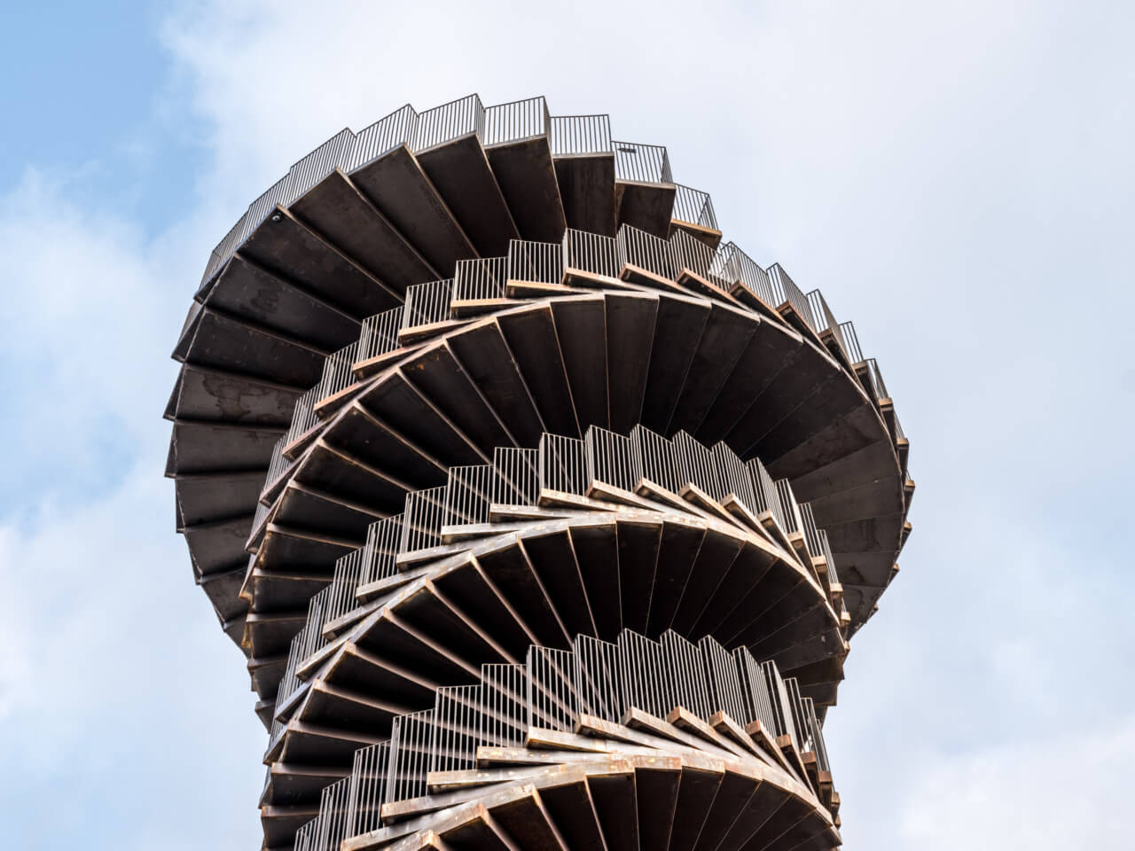 looking up at the top half of a spiraling steel observation tower