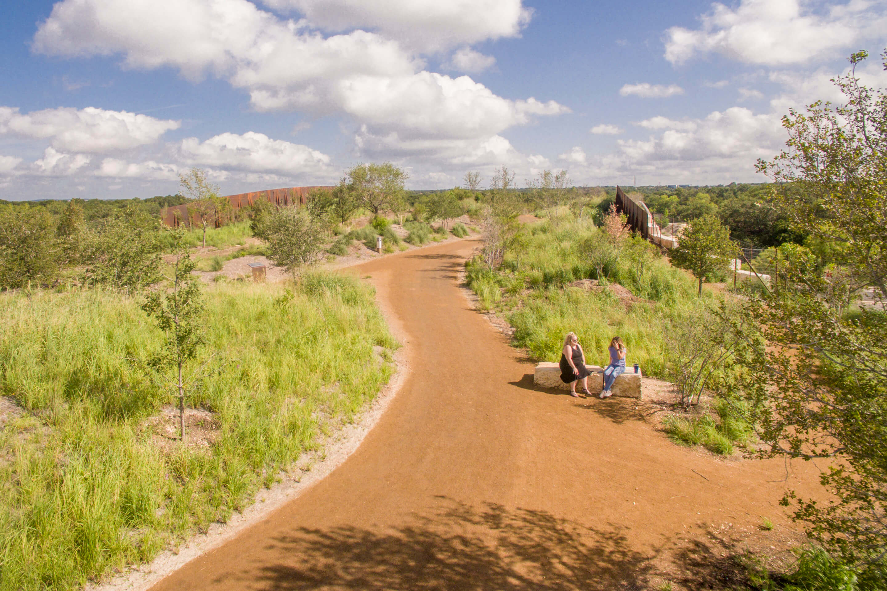 People relaxing on rocks along a dirt path
