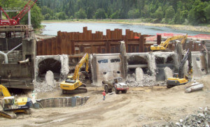 workers remove a dam from a river