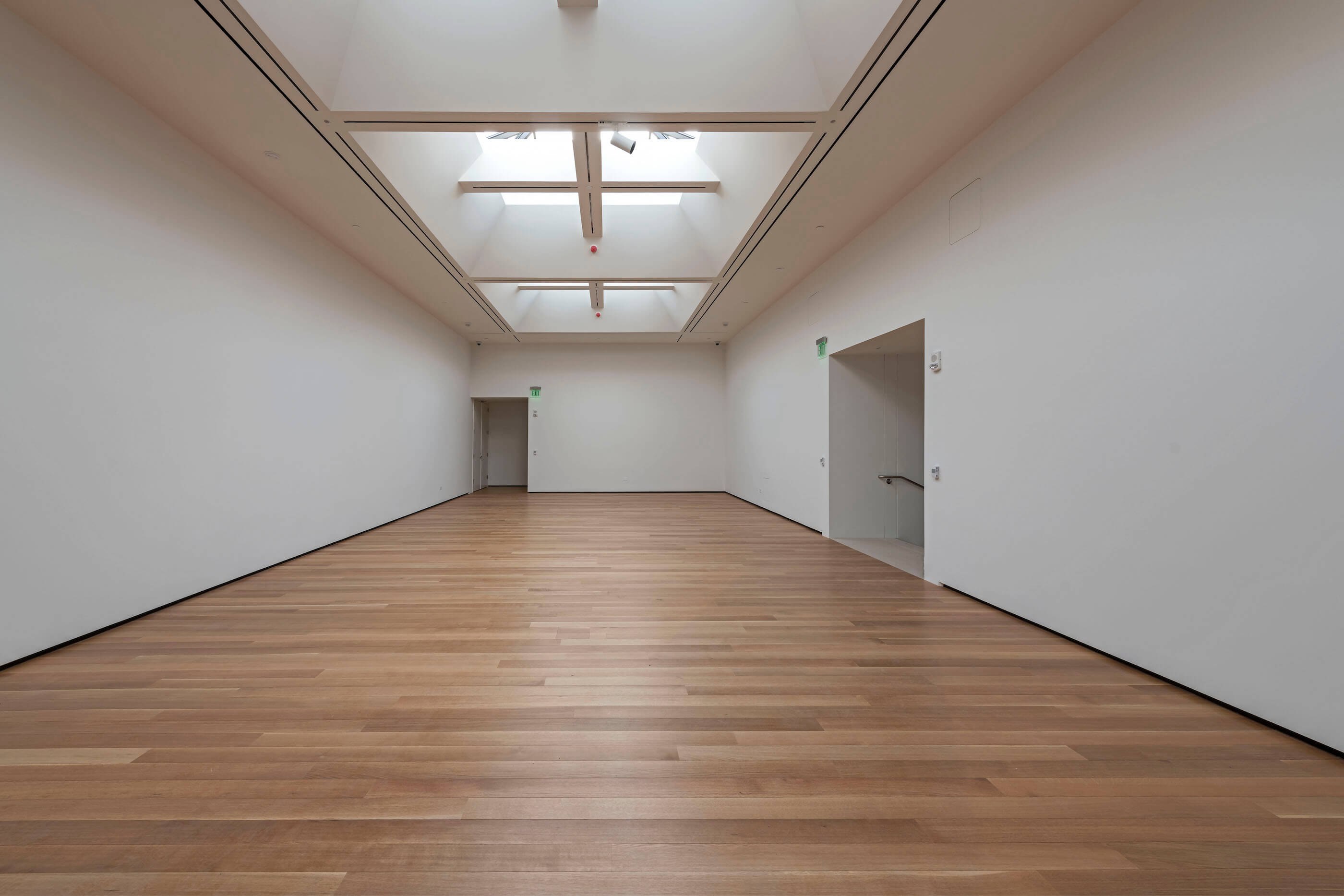an empty gallery space with skylight