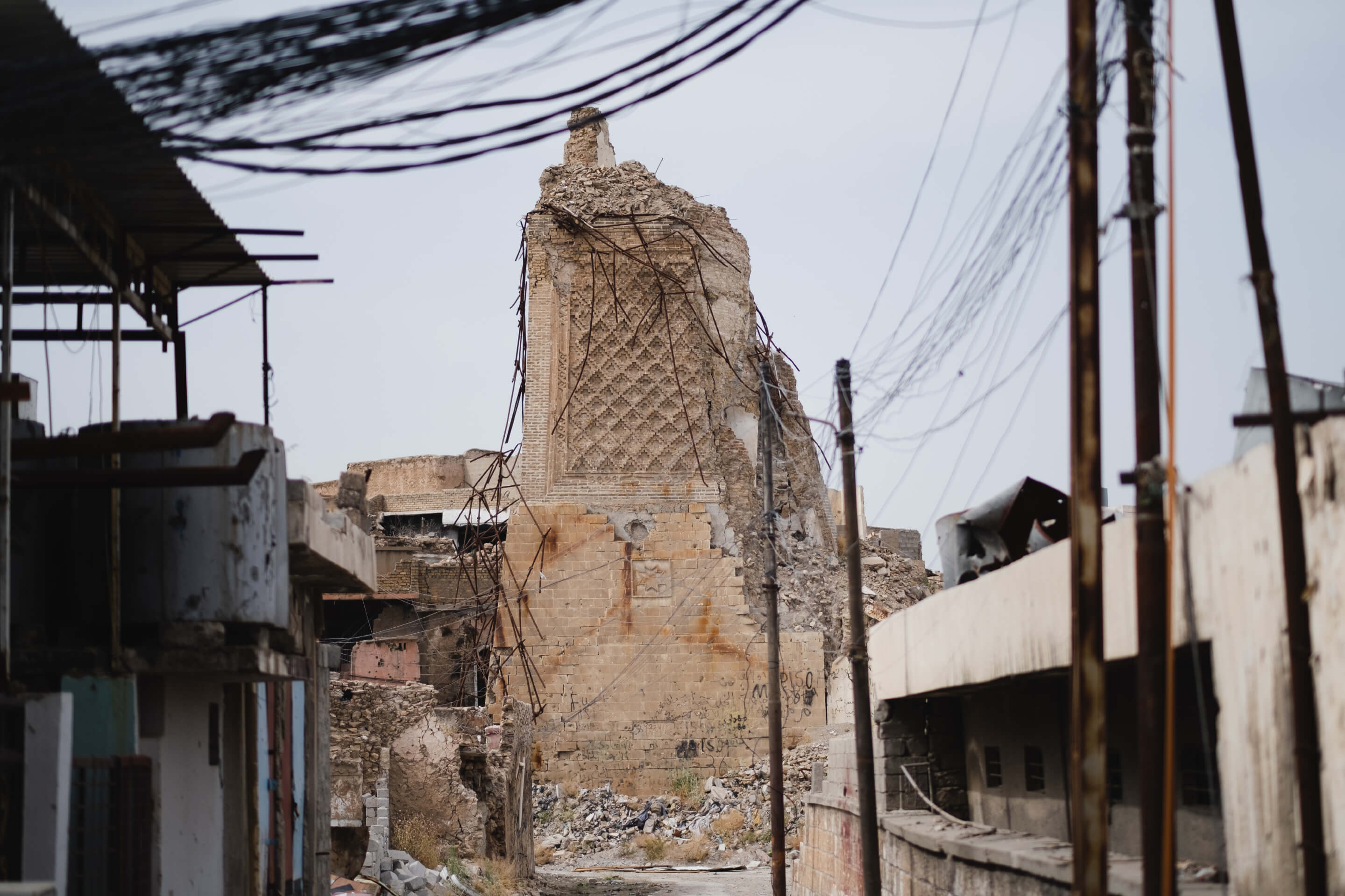 A ruined mosque crumbling amid power lines