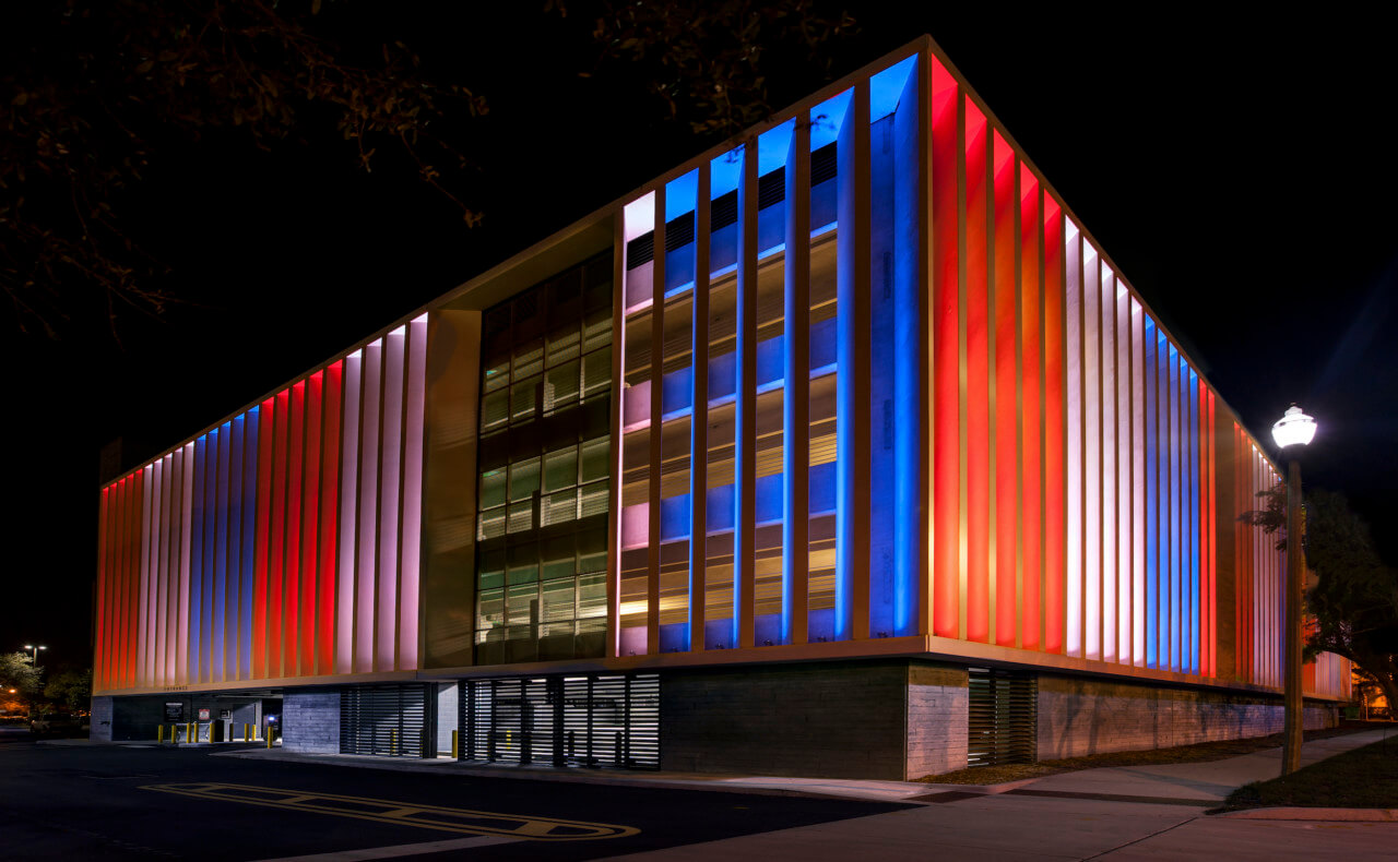 a parking structure colorfully illuminated at night