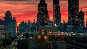 The new york city subway line running out of manhattan and into queens at sunset