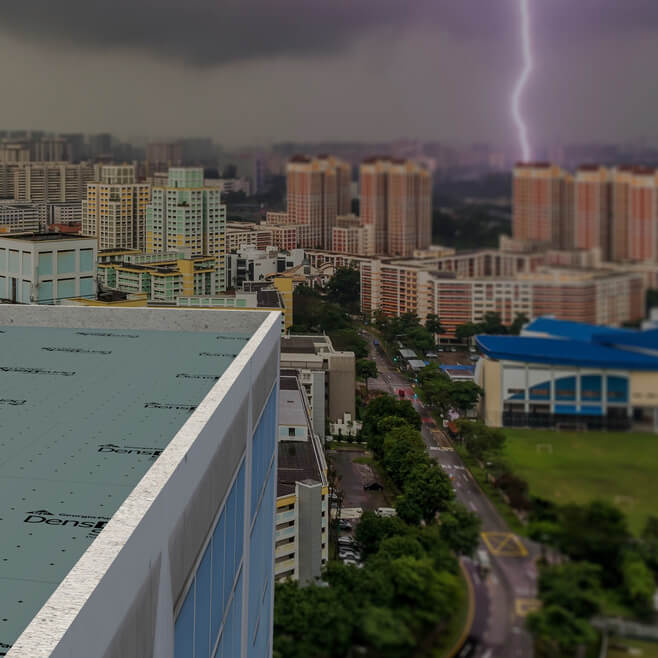a building in front of a city with a lighting strike
