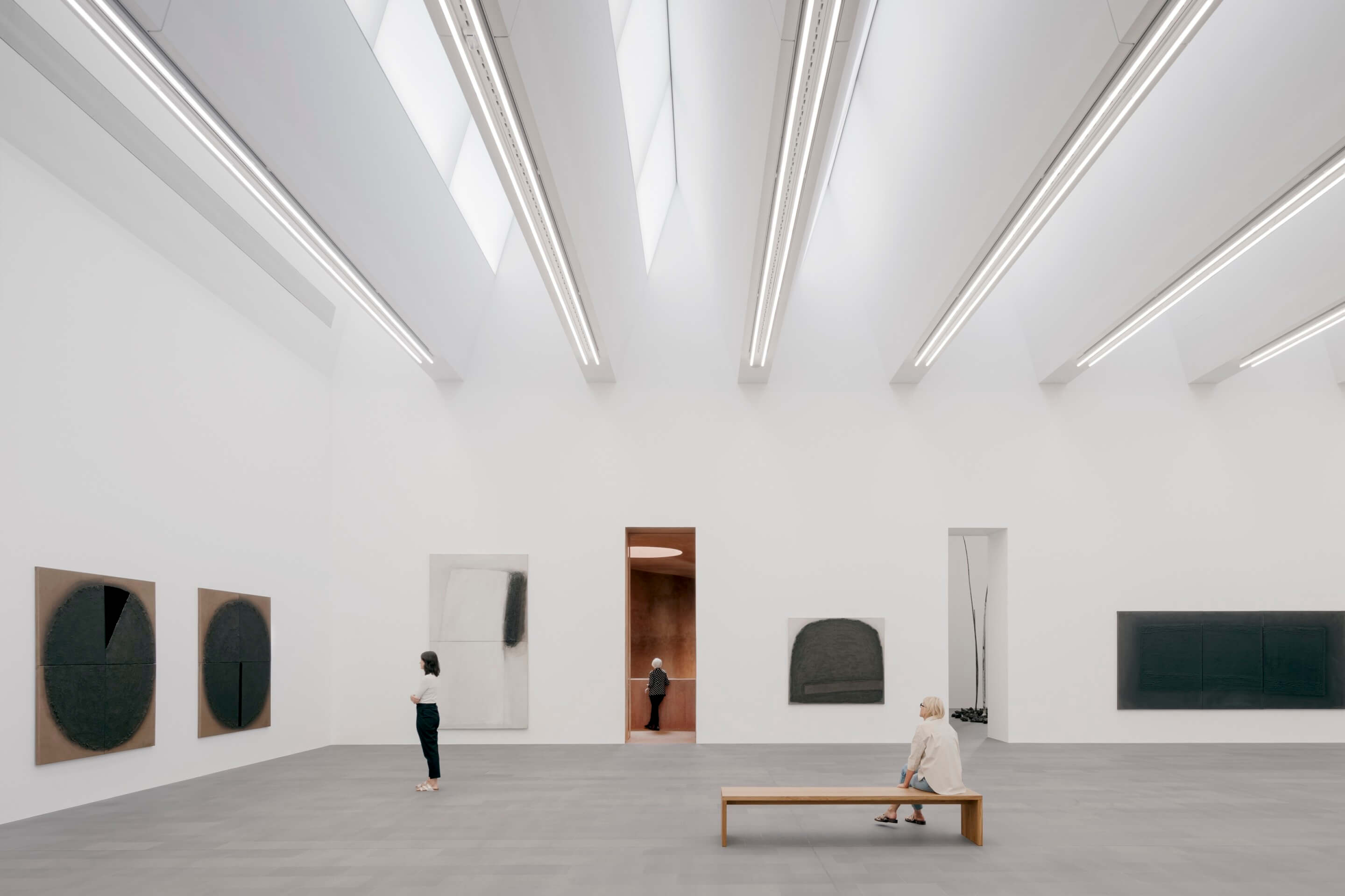 an airy, all-white gallery space with modern paintings on the walls