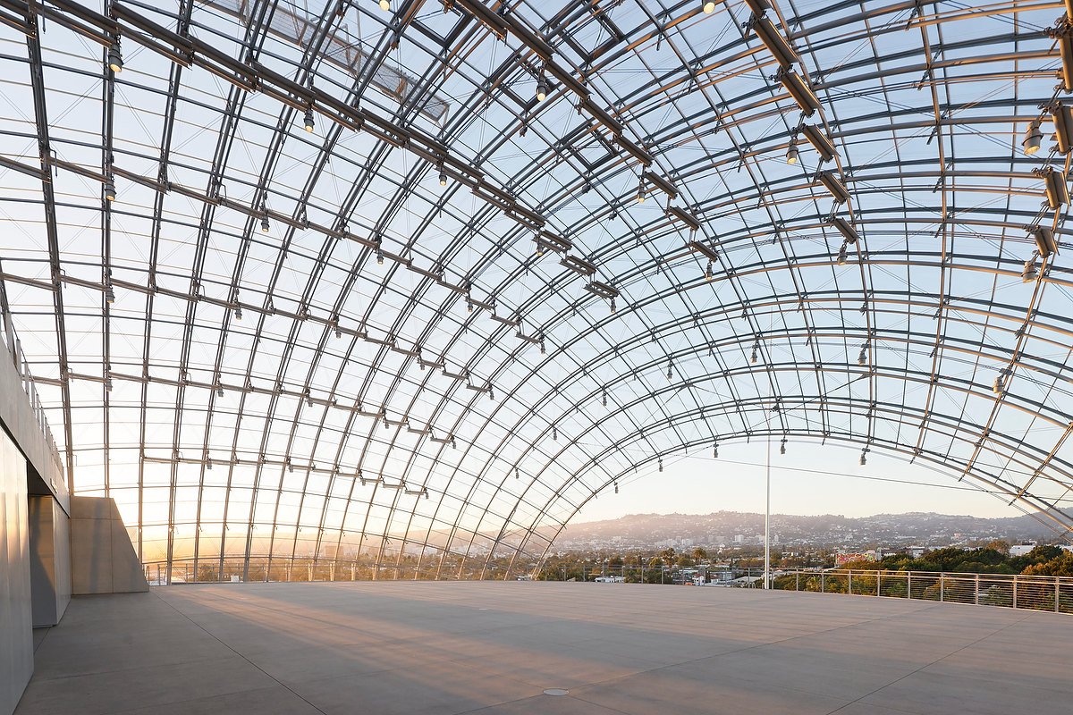 exterior photograph of a glass-and-steel dome ceiling with a view to the Los Angeles hills