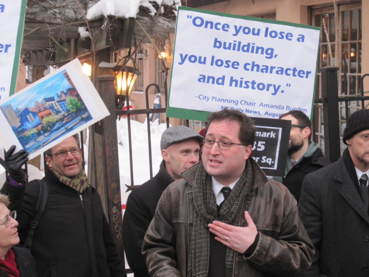 Simeon bankoff in front of a crowd of protestors with signs