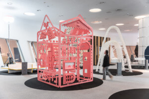 a coral-painted, chalet-inspired installation at an exhibition, fabricating swissness