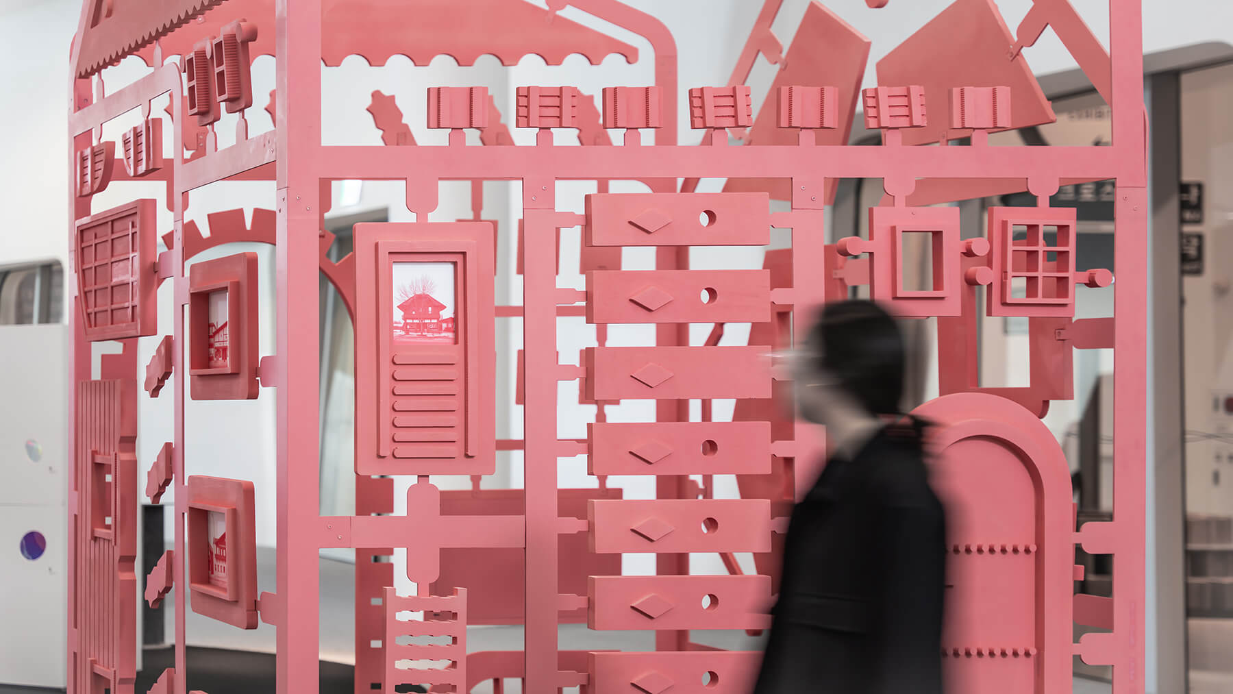 a coral-painted, chalet-inspired installation at an exhibition, fabricating swissness