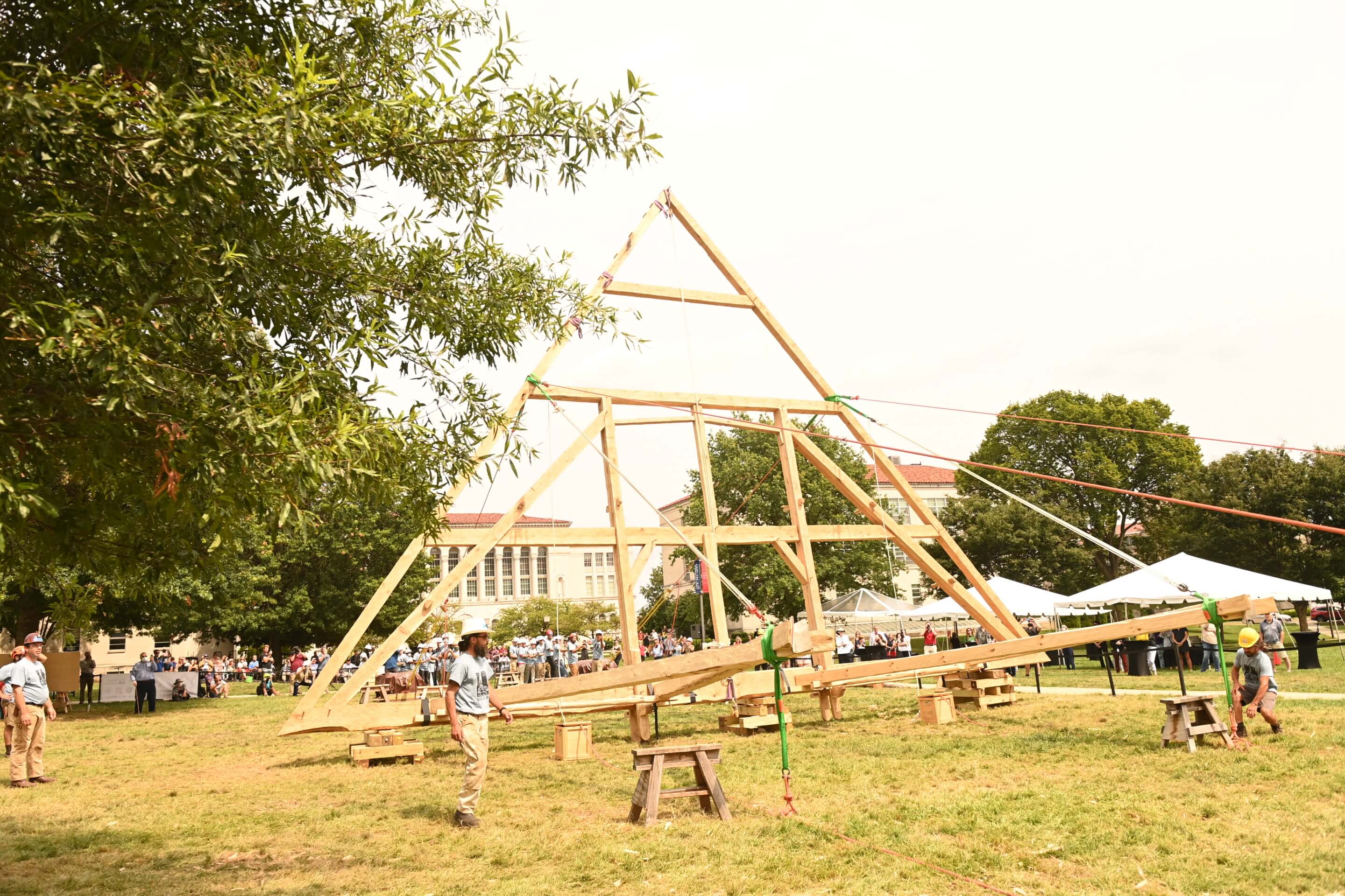 Students raising a triangular timber truss