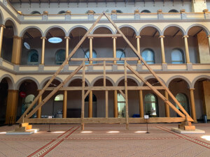 A truss destroyed in the notre dame fire, raised at the national building museum