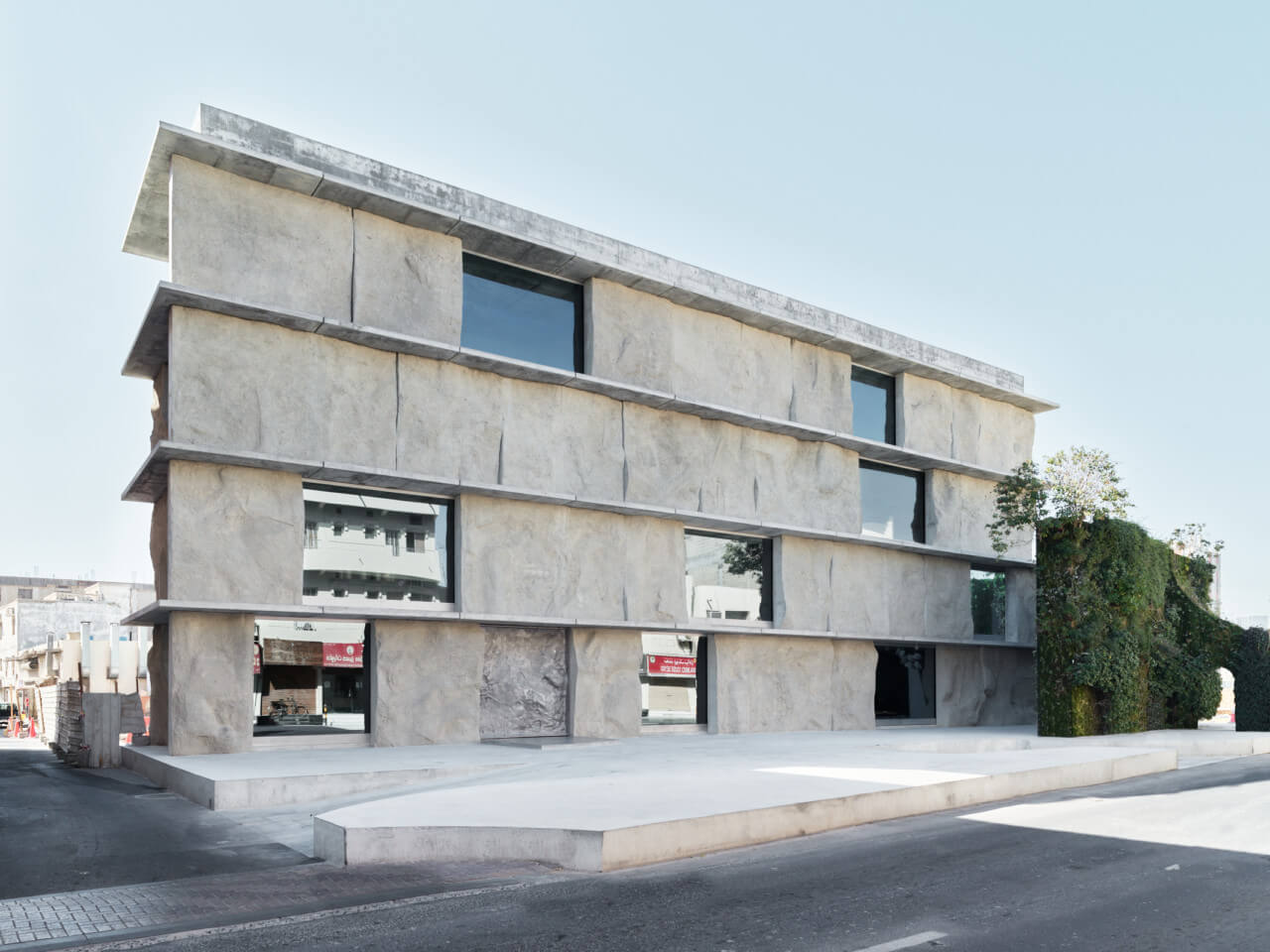 the exterior of a stone like facade on a flat building designed by Studio Anne Holtrop