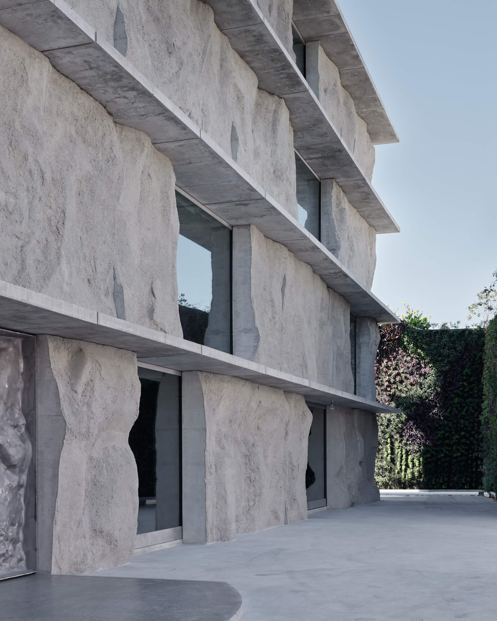 Vertical image of a stone building designed by Studio Anne Holtrop with rough slabs between floors