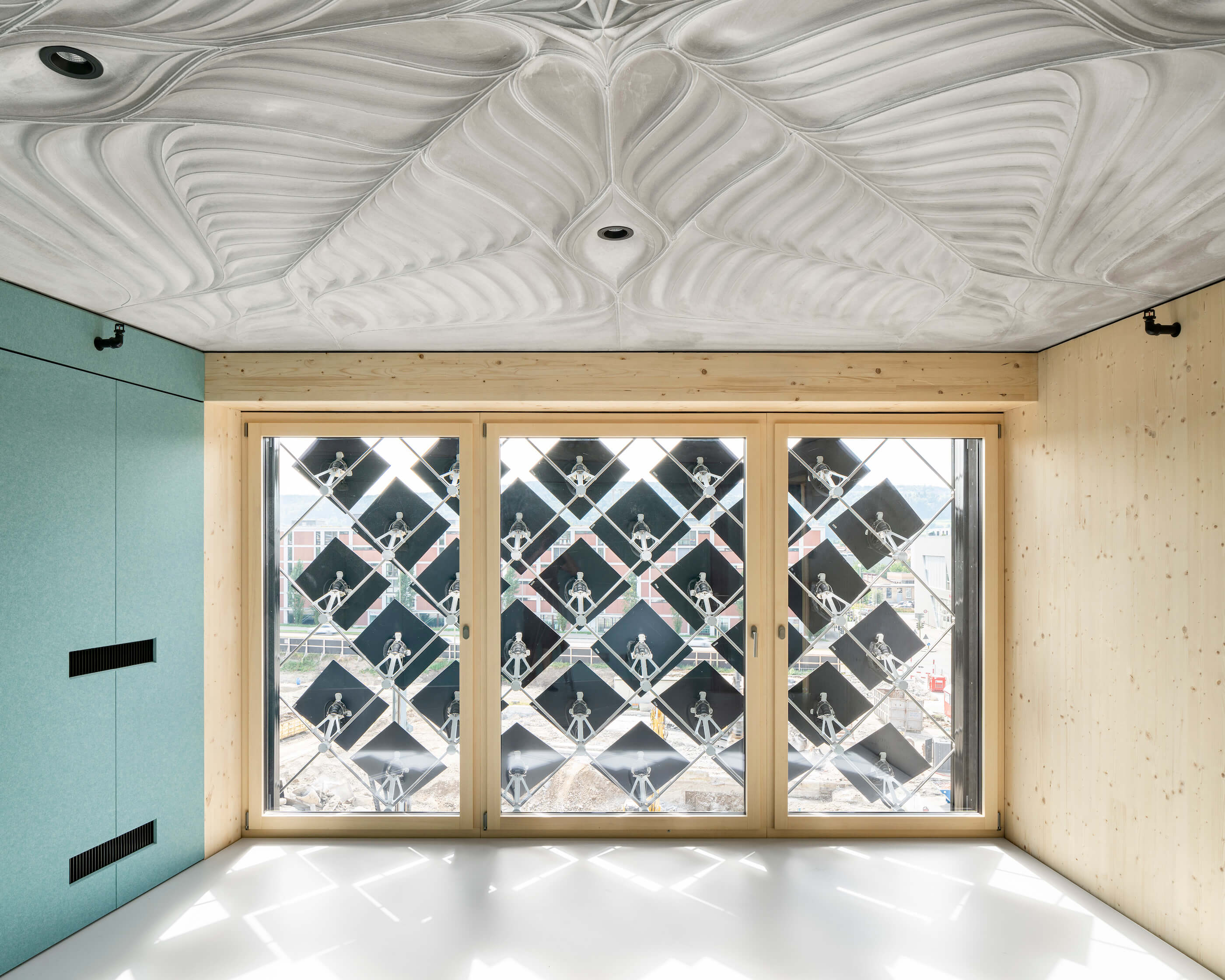 a room with an intricate concrete roof structure and pv panels affixed to a window