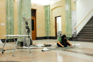 a syracuse student on the ground installing a piece from beyond the surface