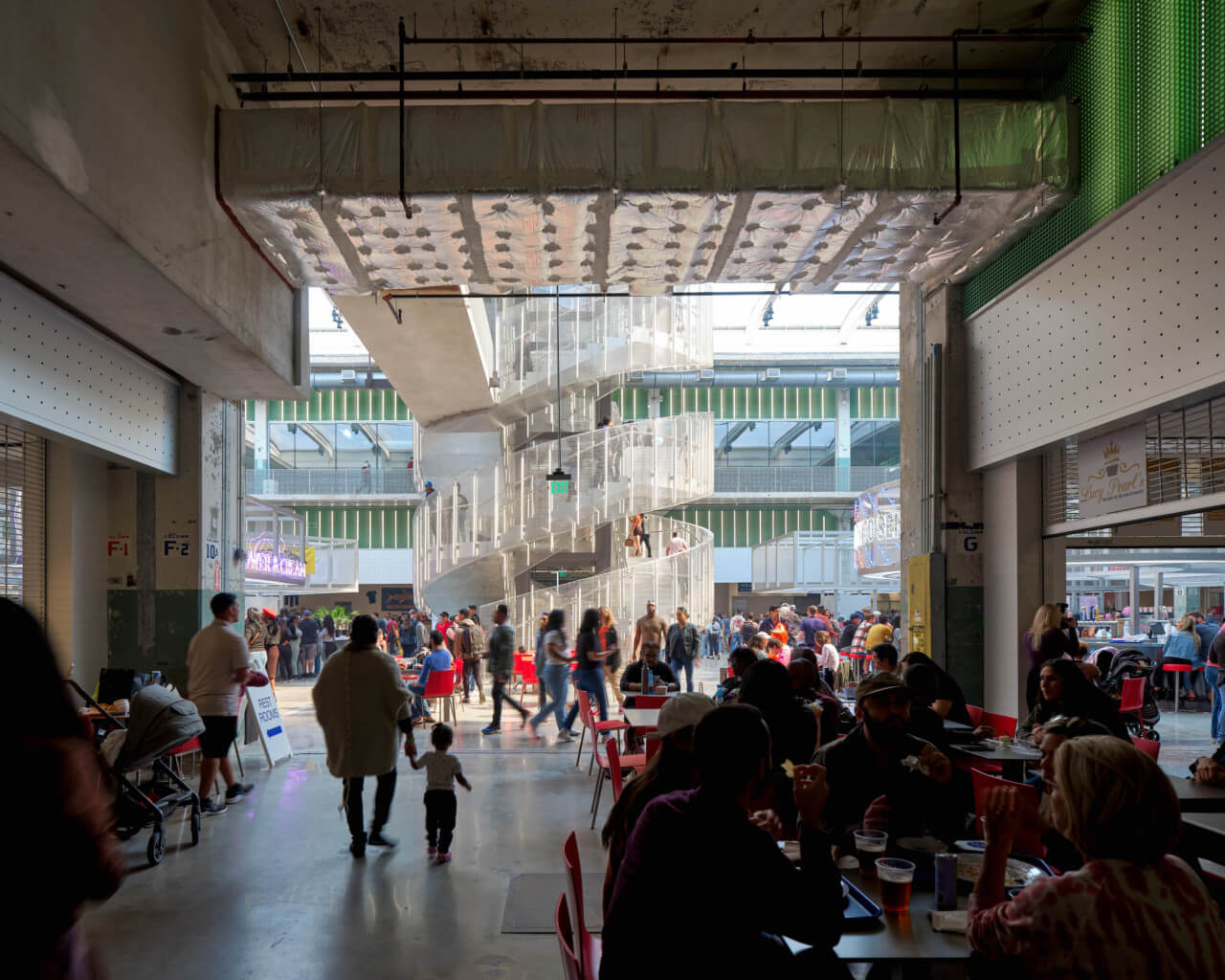 people congregate in a food hall in a former industrial space