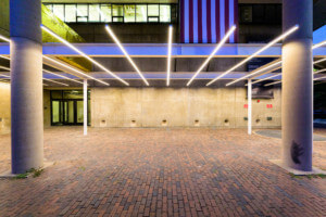 an array of LED lights and american flag above an outdoor plaza at an academic building