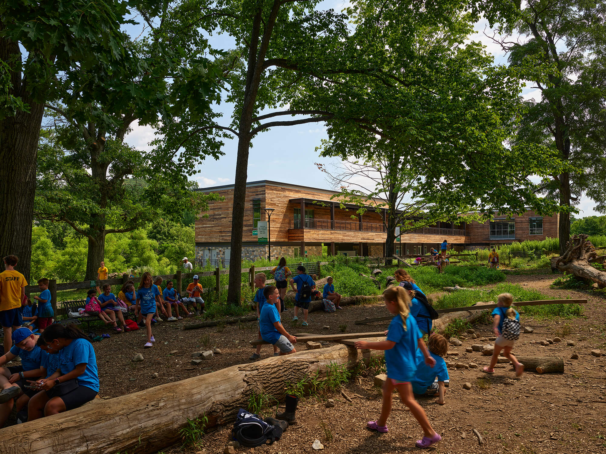 kids in blue shirts at summer camp frolic in the dirt