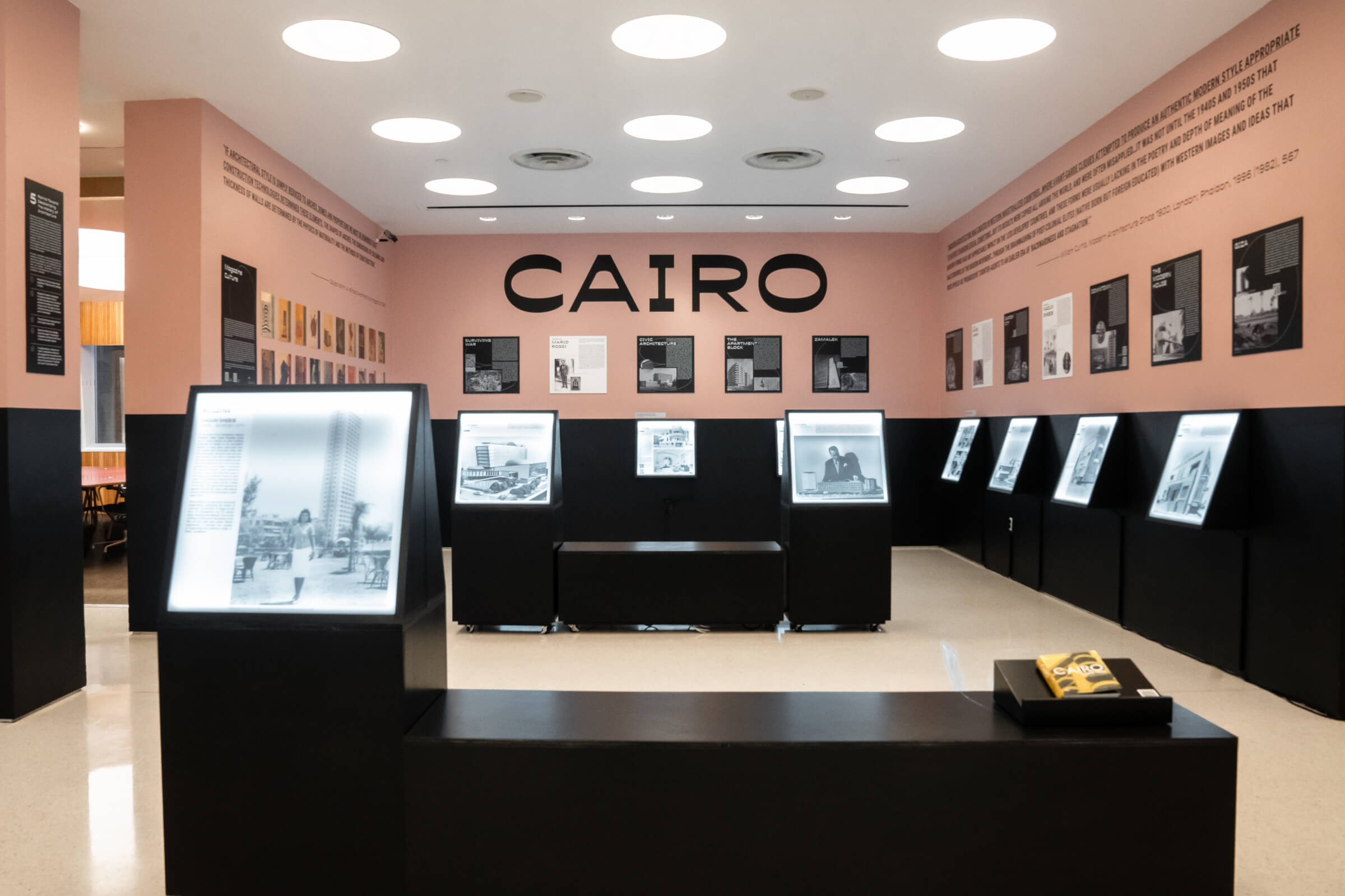 Interior of a pink walled gallery with cairo modern signs