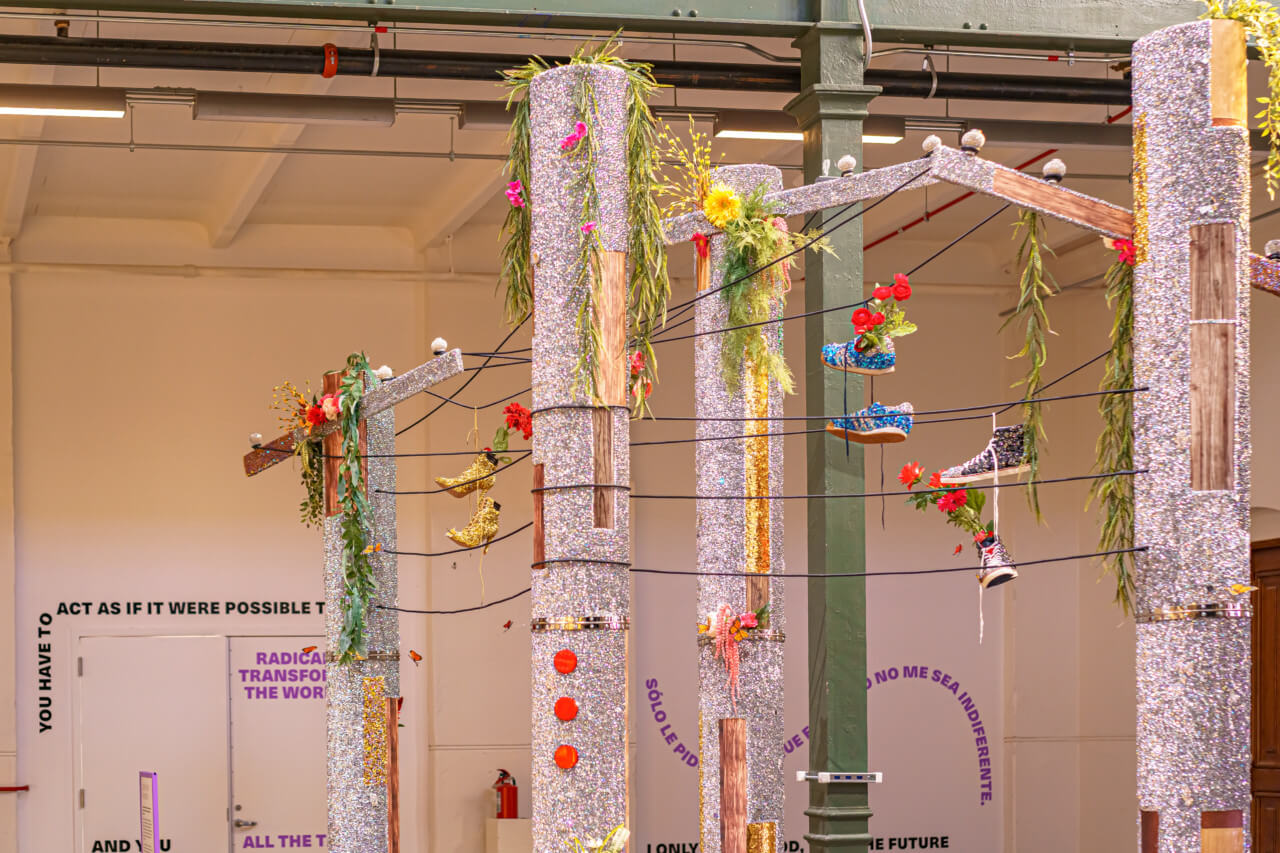an art installation with rhinestone-clad telephone poles and fake flowers