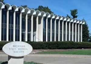 a modernist office building with a scalloped roofline with a Michigan State Medical Society sign