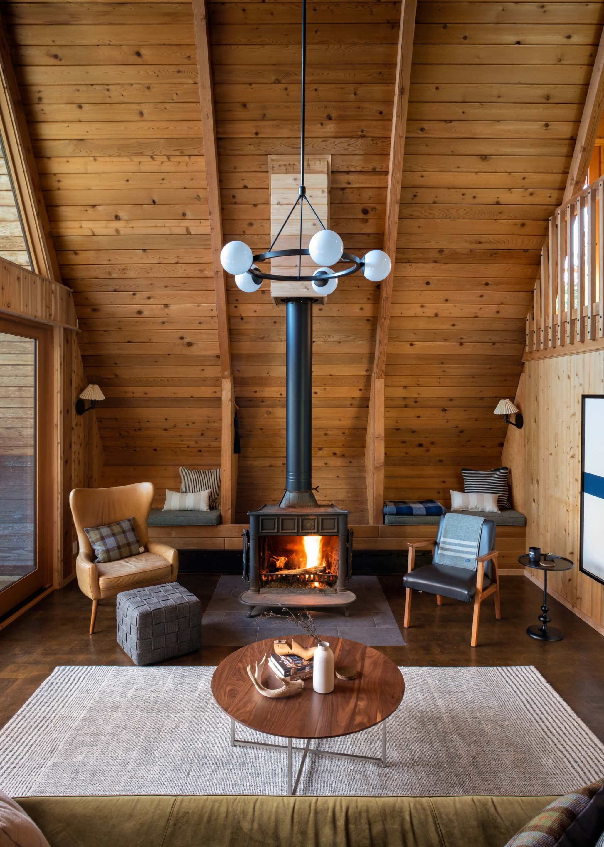 a stove in a cozy, wood-paneled cabin