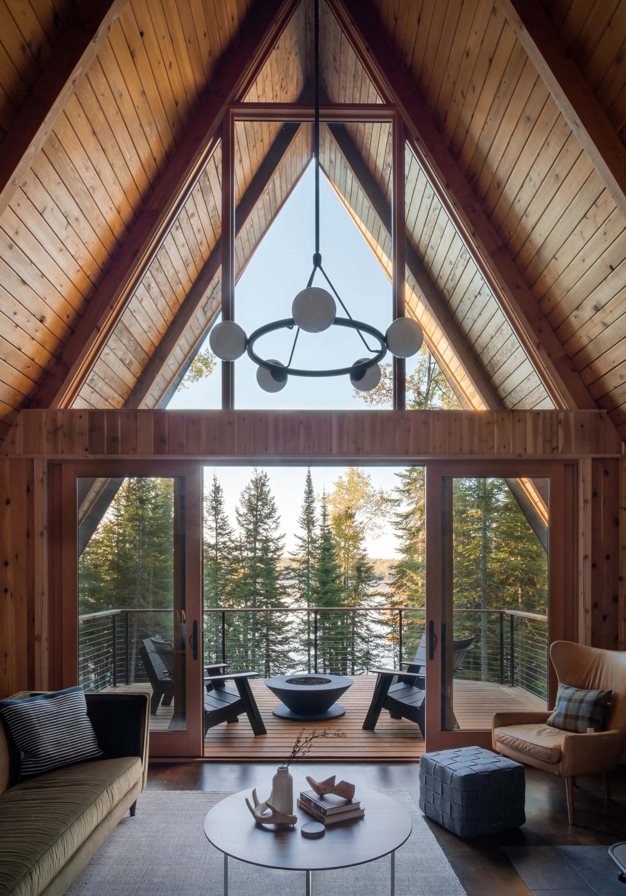 looking out from an a-frame cabin to a wooded lake scene