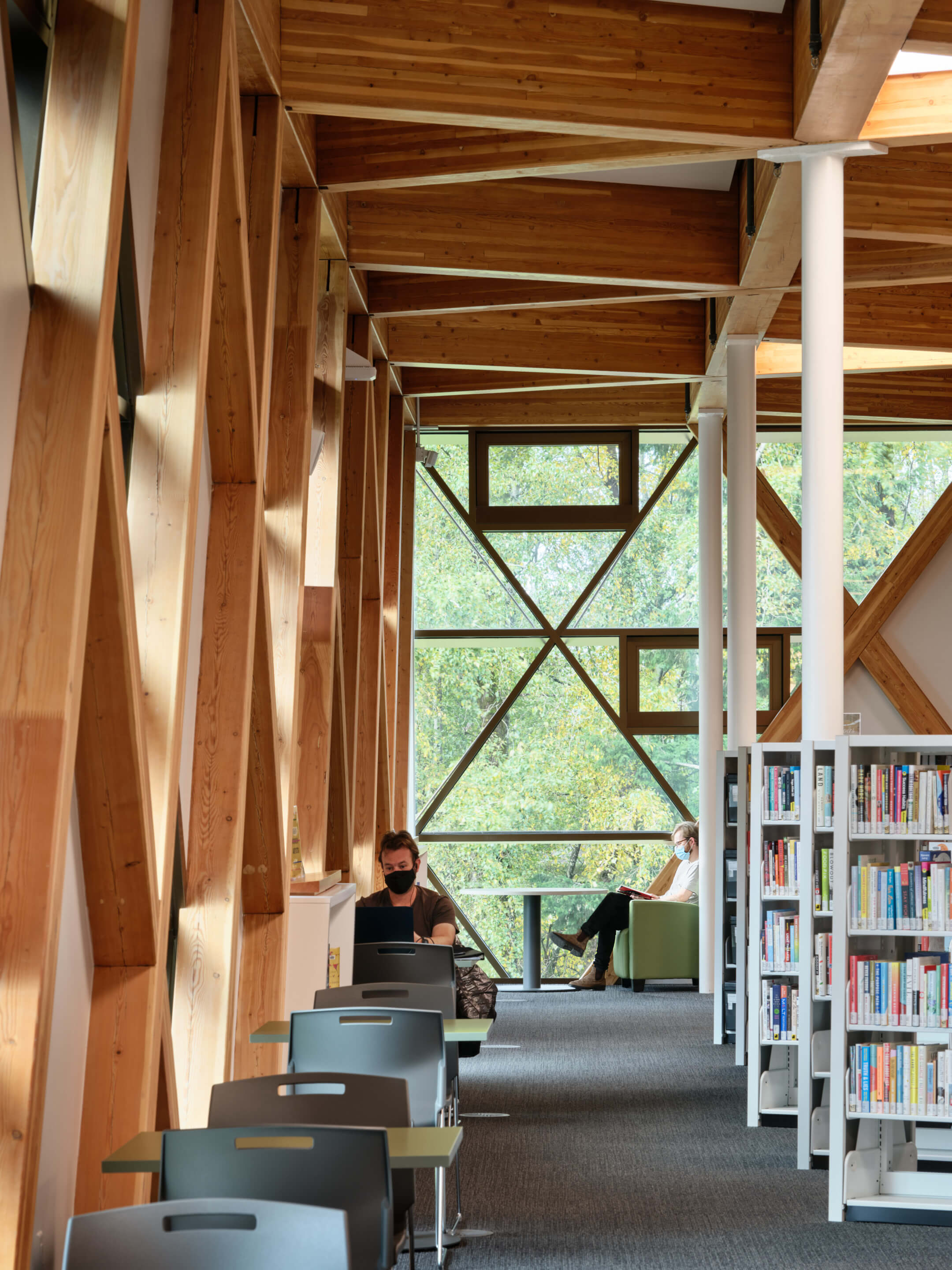 patrons sit inside a library with timber features