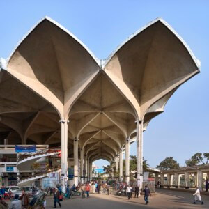 photograph depicting a train station with a scalloped, sculpture concrete roof
